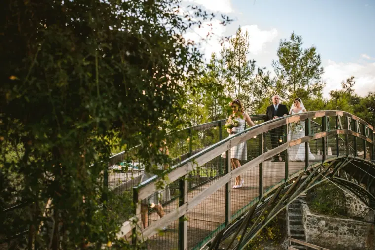 Bridesmaids crossing the arched footbridge towards the ceremony at Lexeko Estate