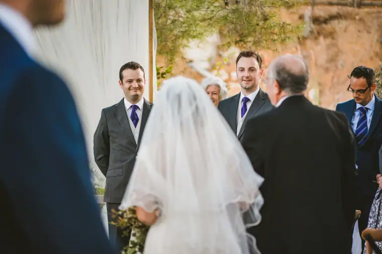 Bride's father giving her away to the waiting groom at the ceremony