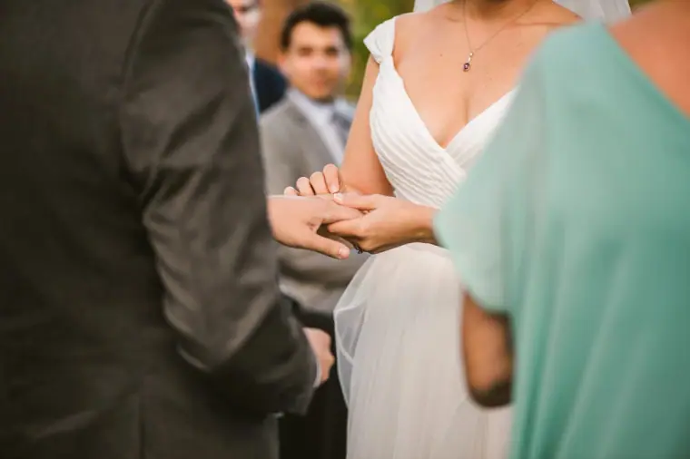 Close-up of the couple holding hands during the ring exchange