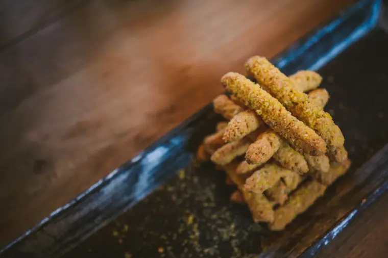 Breadsticks with pistachio on a dark slate platter
