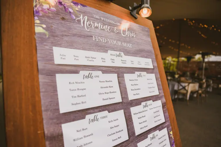 Find your seat table plan with Nermine and Chris's names on a wooden board