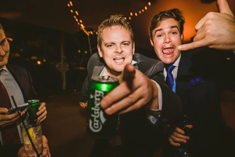 Guests pulling faces and pointing at the camera at the late-night party under fairy lights