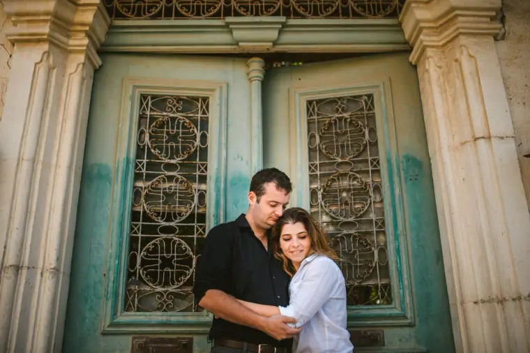 Couple framed by carved stone pillars and a faded turquoise door