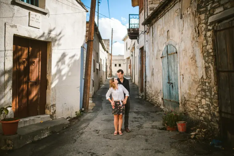 Couple standing together in a narrow alley of old stone houses