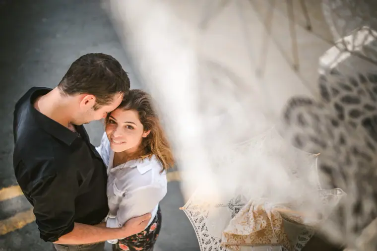 Couple embracing, seen through a blurred lace curtain