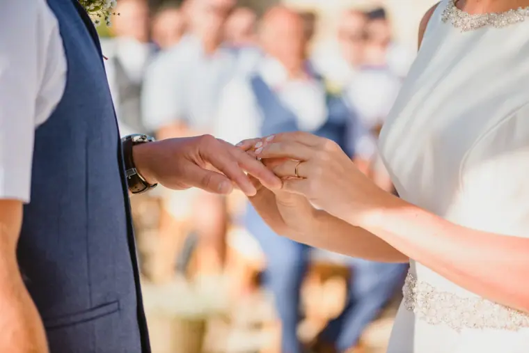 Close-up of the ring being placed on the bride's finger