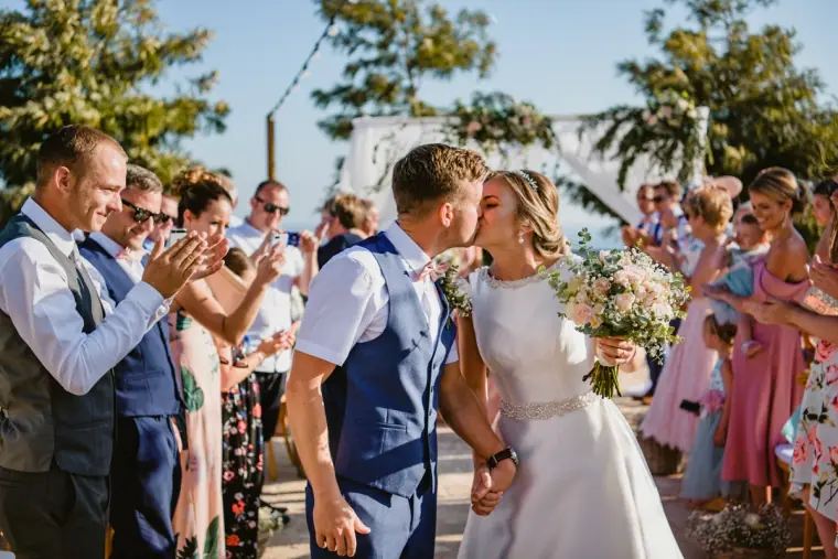Couple kissing amid applauding guests after the ceremony at Liopetro