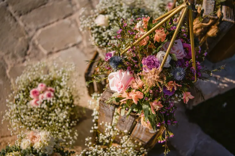 Pastel flowers in gold geometric holders on the reception tables