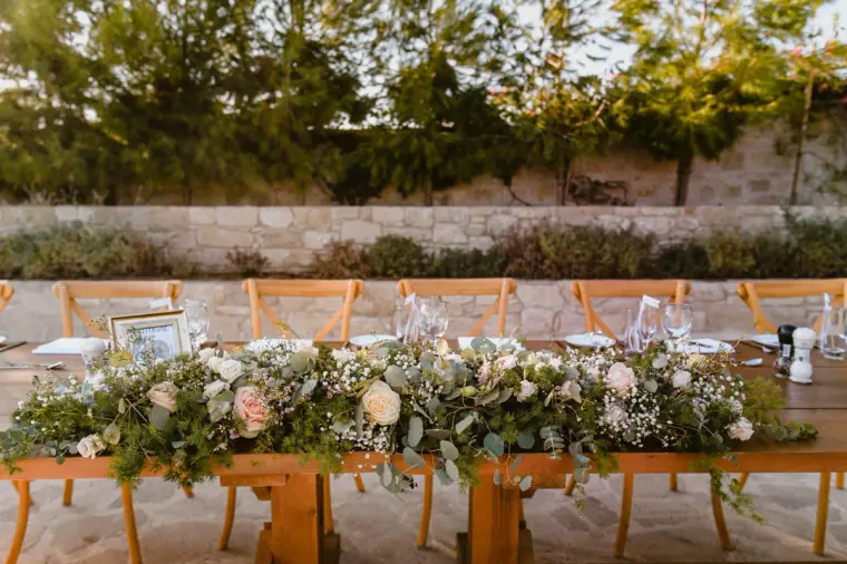 Top table garland of roses and greenery on a long wooden table