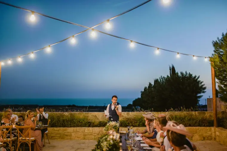 Guests dining under festoon lights at dusk on the terrace at Liopetro, Kouklia
