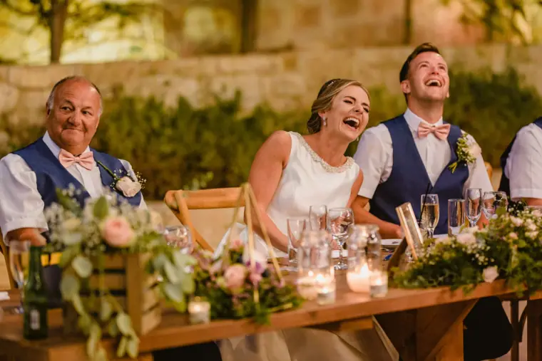 Bride and groom laughing at the top table during the speeches