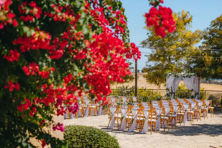 Red bougainvillea framing rows of ceremony chairs on the terrace at Liopetro, Kouklia