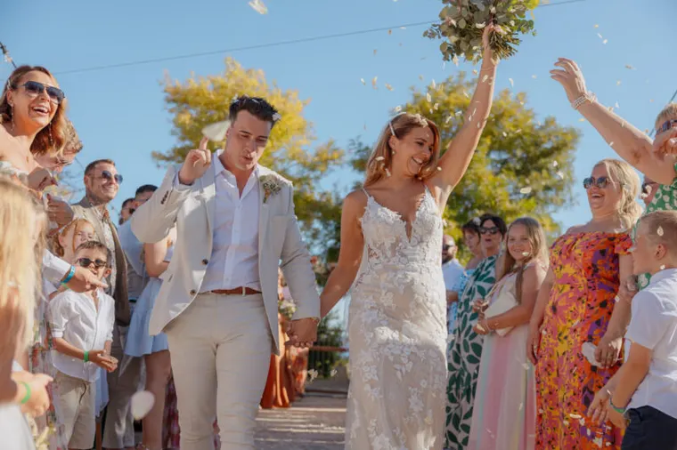 Bride throwing her bouquet in the air as guests toss confetti at Liopetro, Kouklia