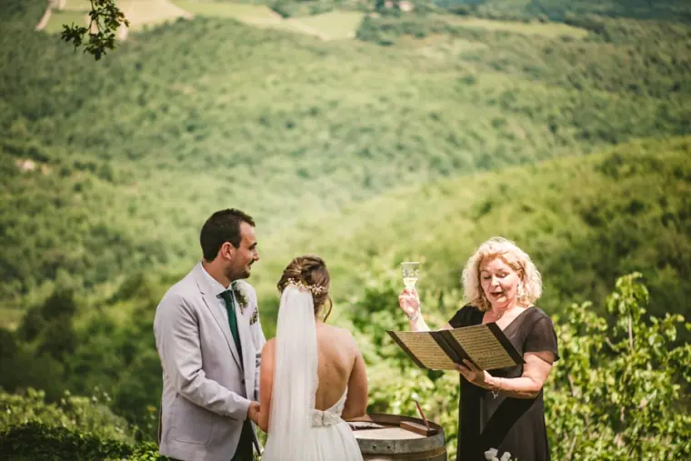 Couple facing the celebrant with forested Tuscan hills behind them at Livernano Estate