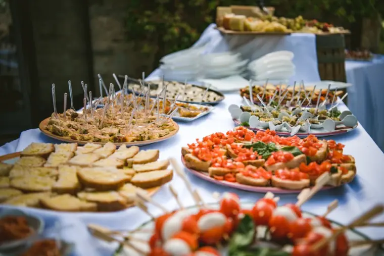 Antipasti buffet of bruschetta, caprese skewers and canapés on a white tablecloth
