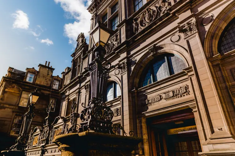 Looking up at an ornate carved stone facade and lamp post in Edinburgh