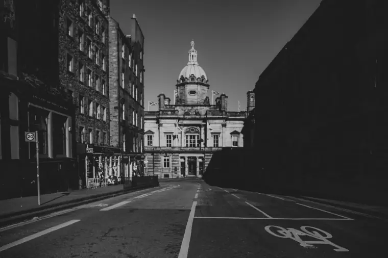 Black-and-white view down an empty street towards a grand domed building, Edinburgh