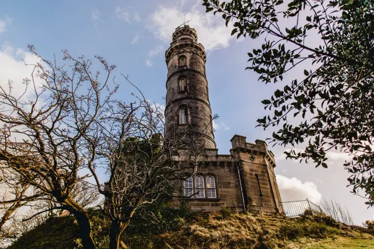 Nelson Monument tower on Calton Hill seen from below through branches