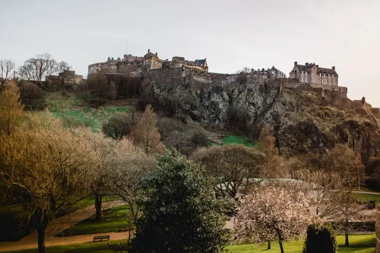 Edinburgh Castle above Princes Street Gardens with blossom trees in spring