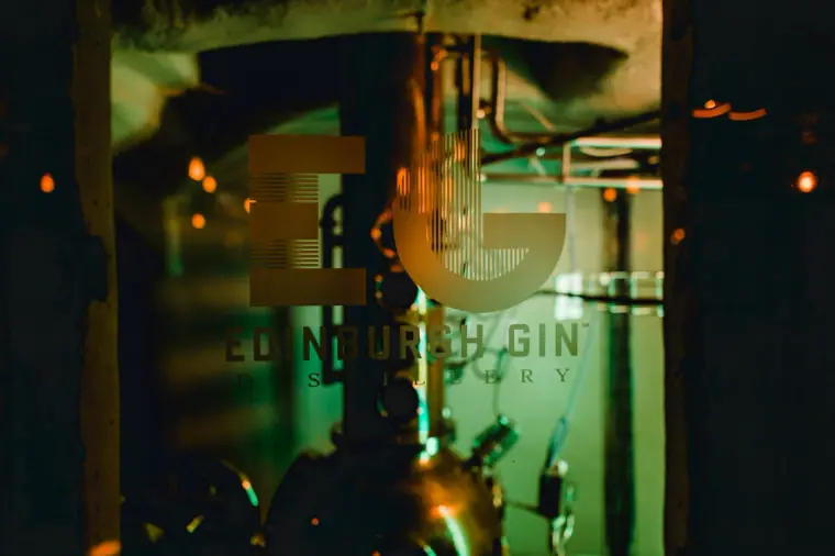 Edinburgh Gin logo etched on glass in front of a copper still