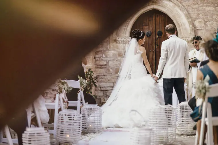 Bride and groom holding hands before the chapel's wooden doors