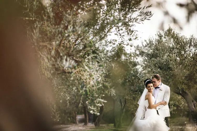 Couple holding each other beneath olive trees at Minthis Hills