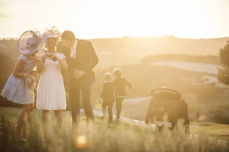 Guests and children in golden backlight on the hillside at sunset, Minthis Hills