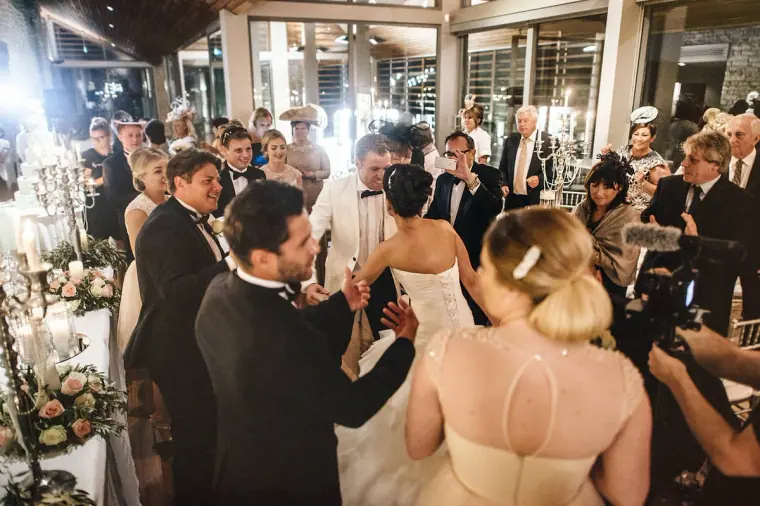 Guests crowding the dance floor around the newlyweds at the reception