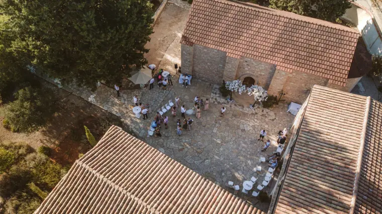 Aerial view of guests in a courtyard between terracotta tiled roofs
