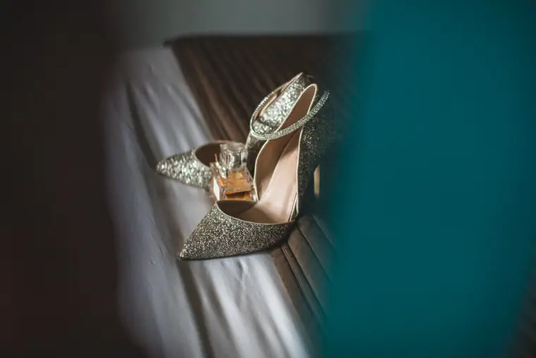 Sparkly pointed bridal shoes resting on a windowsill in soft light