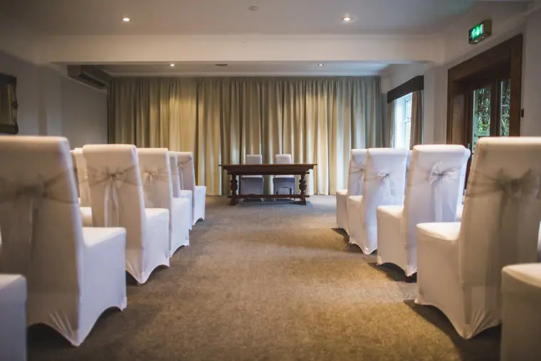 Ceremony room with white-covered chairs either side of the aisle at Balmer Lawn Hotel