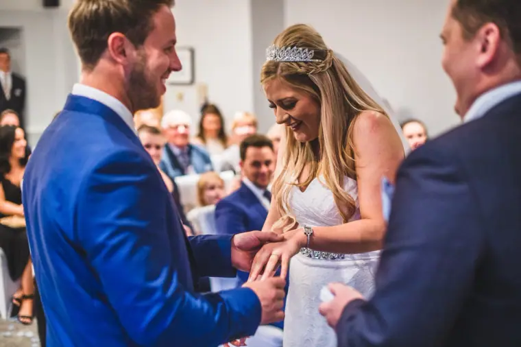 Lyndsay and Thomas exchanging rings as the registrar watches at Balmer Lawn Hotel
