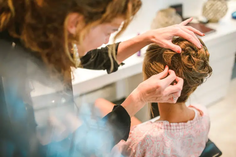 Stylist pinning the bride's hair into an updo