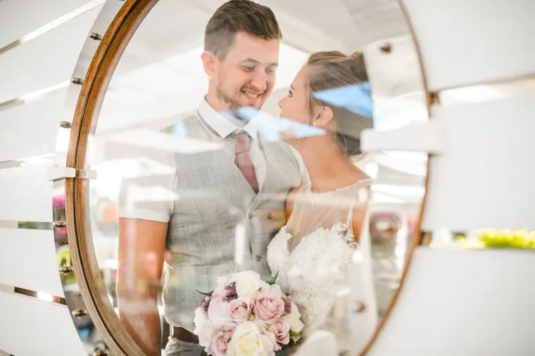 Couple about to kiss, framed through a round wooden window
