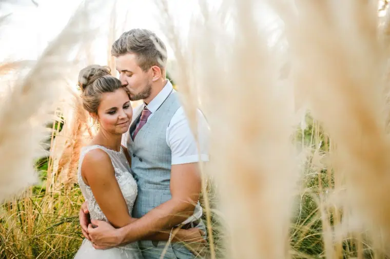 Naomi and Dale embracing among pampas grass at Nissi Beach Resort, Ayia Napa