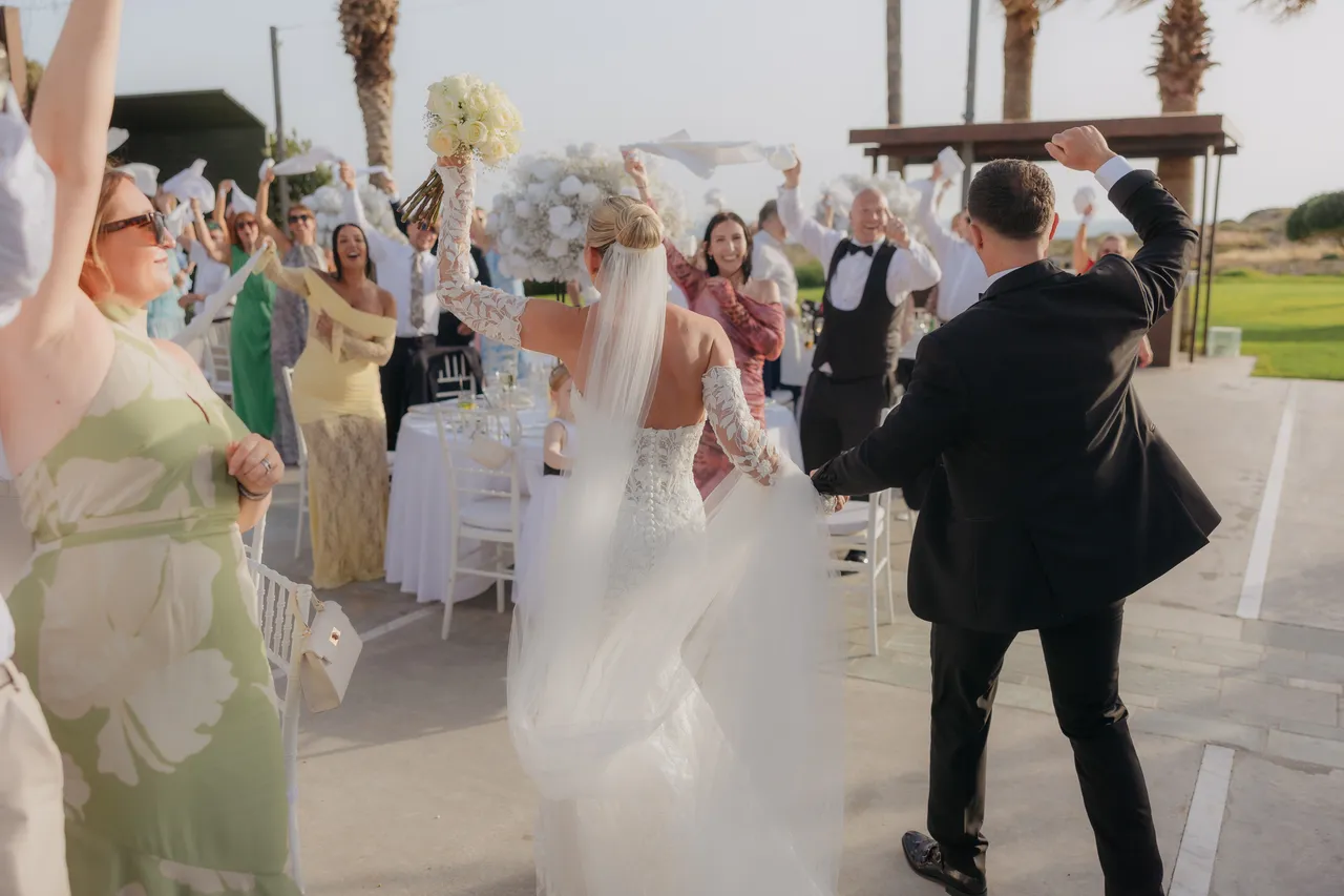 Bride and groom making their grand entrance as guests twirl napkins