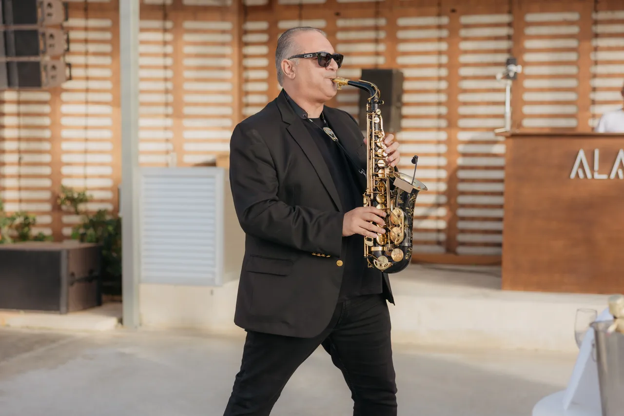 Saxophonist in sunglasses playing at the wedding reception