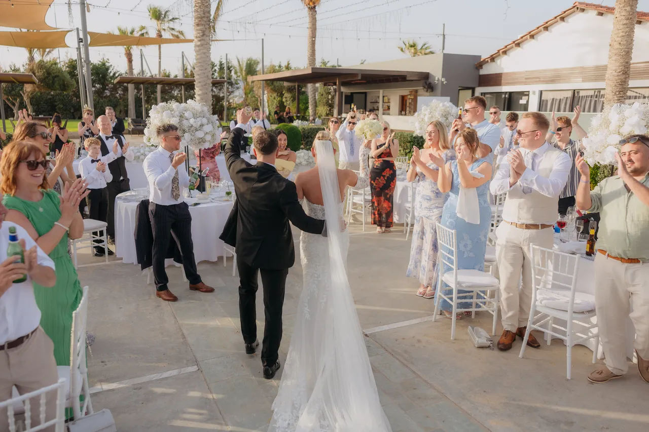 Bride and groom dancing between the tables with guests applauding