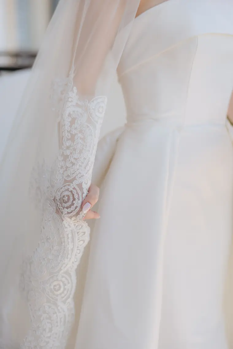 Detail of Poppy's lace-edged veil against her satin gown