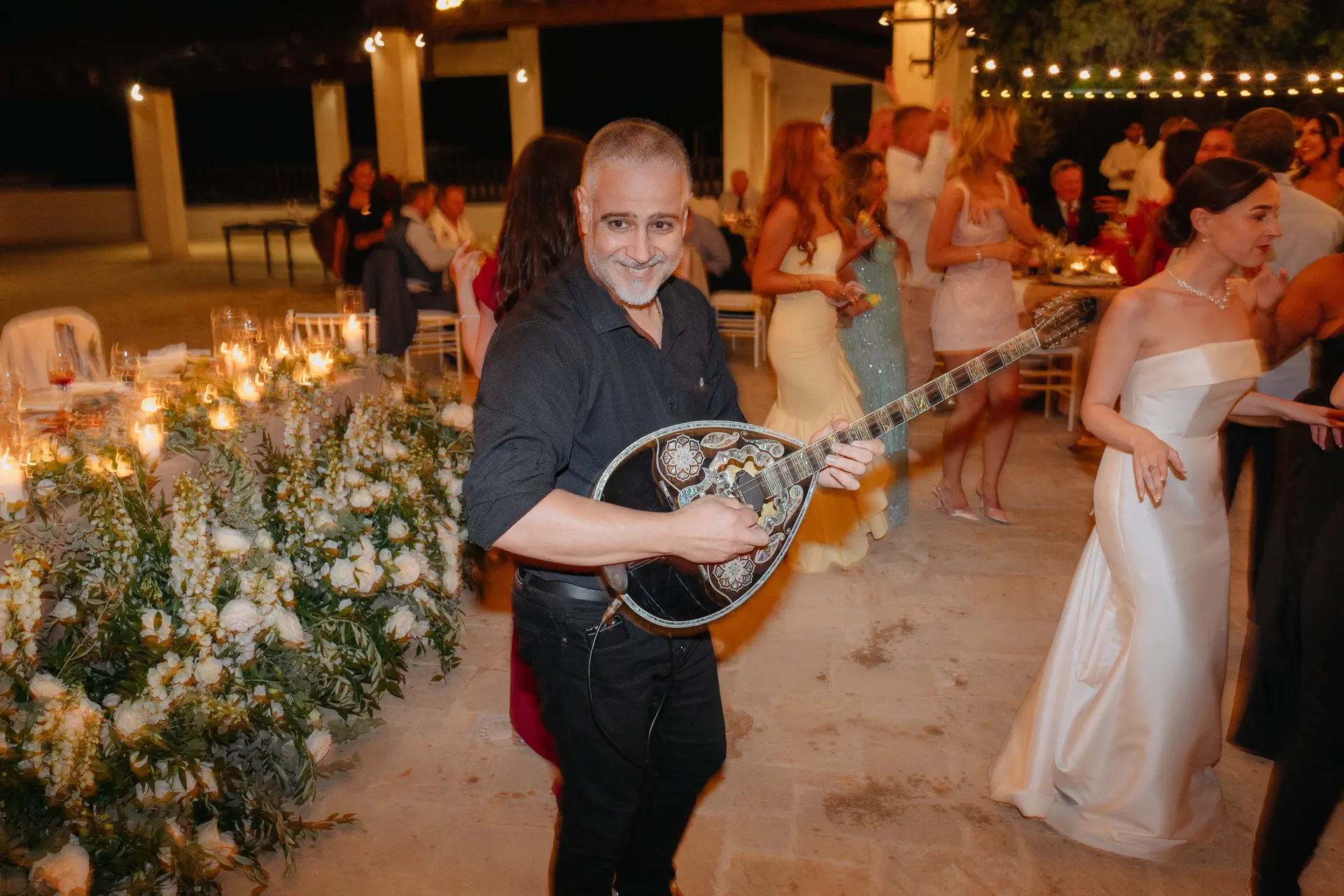 Musician playing a bouzouki beside the bride at the evening reception