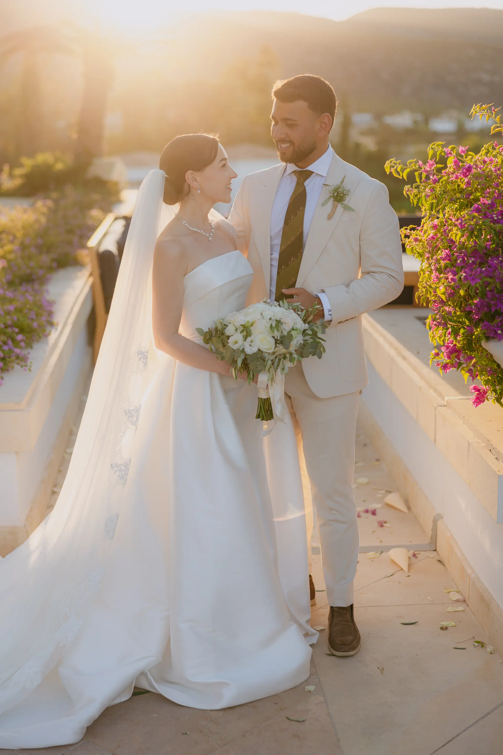 Poppy and Andrew walking together in golden-hour light at Anassa