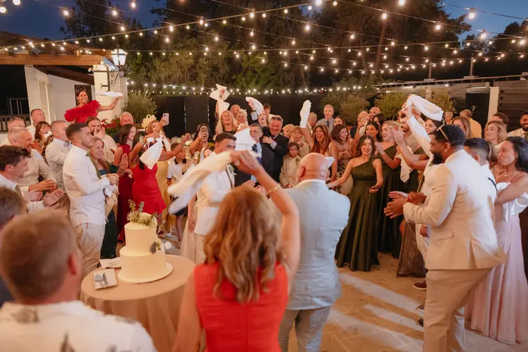 Guests and bridesmaids twirling napkins at the reception entrance