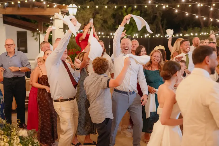 Guests dancing and waving napkins at the evening reception