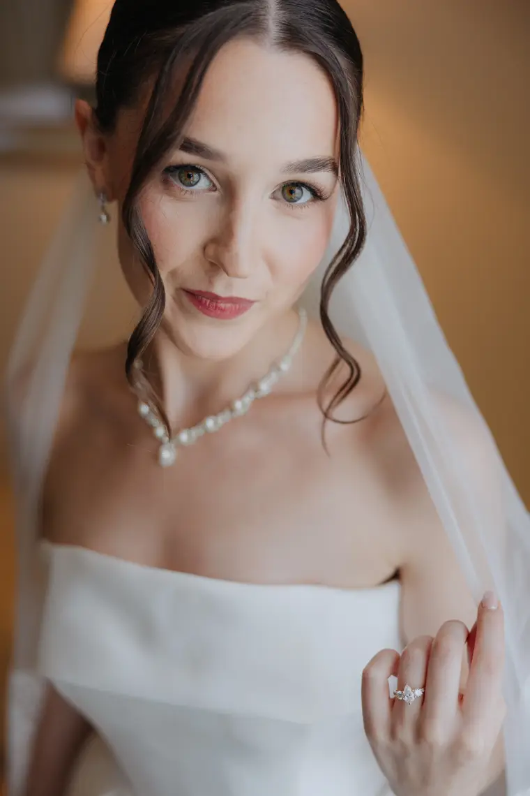 Close portrait of Poppy in her veil and pearl necklace