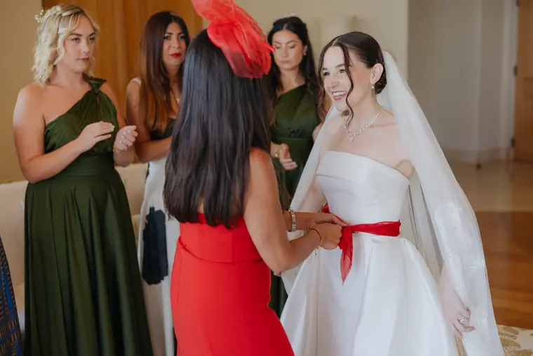 Red ribbon being tied around Poppy's waist during the traditional blessing