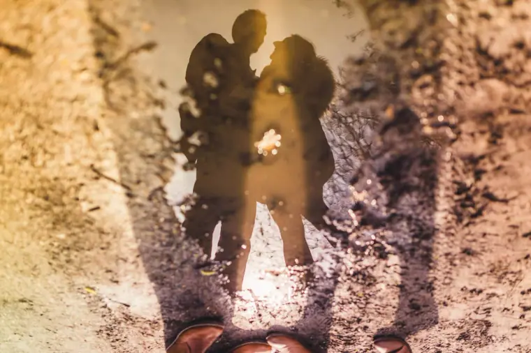 Reflection of the couple kissing in a puddle