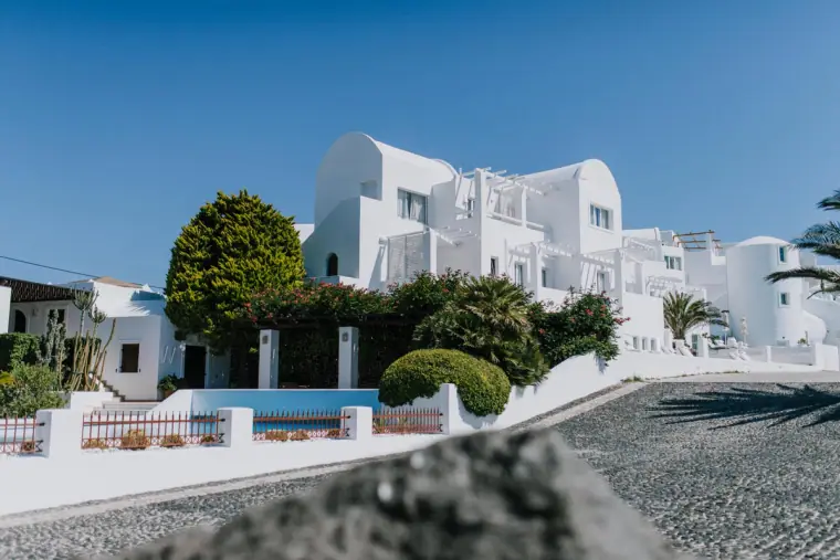 Whitewashed cave houses and a cobbled lane under a clear blue sky in Santorini