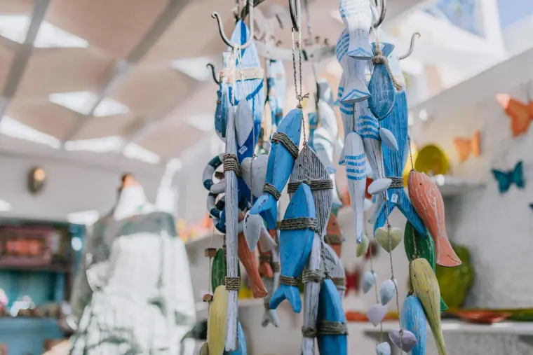 Blue ceramic fish ornaments hanging in a Santorini gift shop