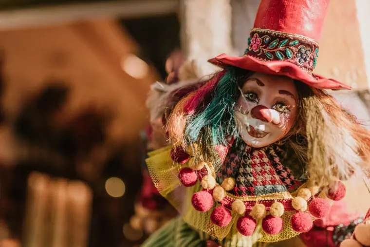 Close-up of a clown puppet in a red hat inside a souvenir shop