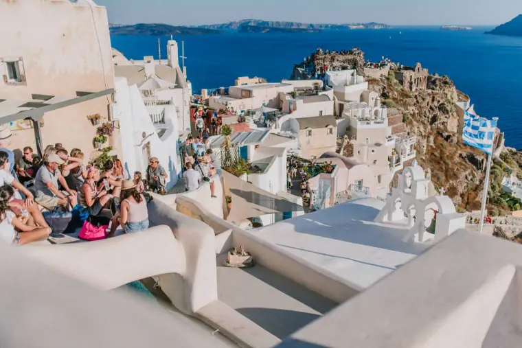 Crowds gathered on white rooftops overlooking the caldera in Santorini